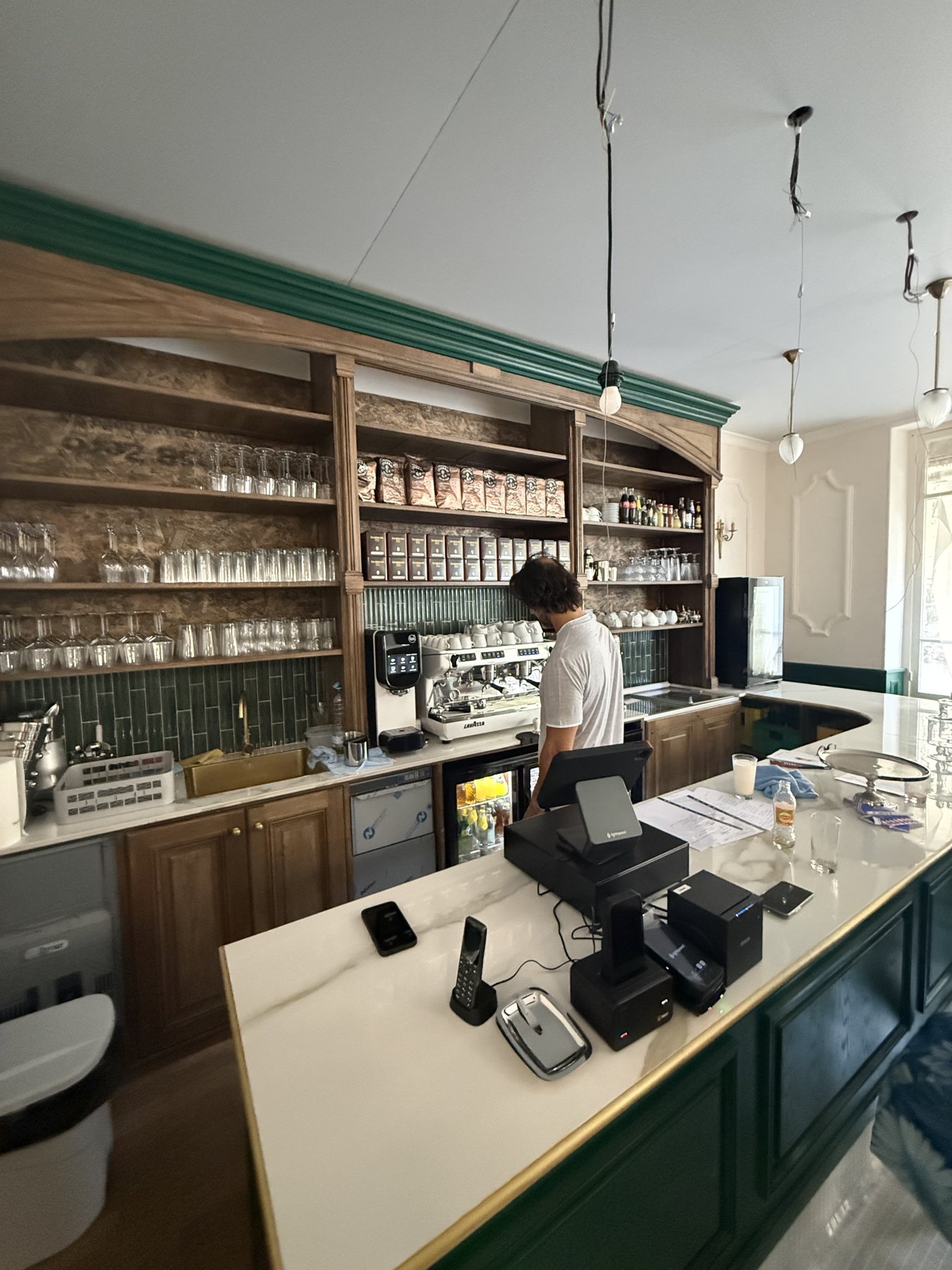 Le comptoir de La Belle Époque : boiseries, faïence verte et machine à café